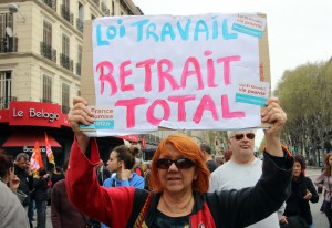 A demonstrator holds a placard reading "Job law, total withdrawal", during a nationwide day of protest, in Marseille, southern France, Thursday, March 31, 2016. Student organizations and employee unions have joined to call for protests across France to reject a government reform relaxing the 35-hour workweek and other labor rules, which they consider as badly damaging hard-fought worker protections. (AP Photo/Claude Paris)