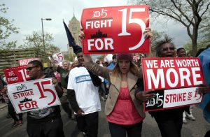 A group of workers and labor activists march down West Grand Boulevard as they demand a raise in the minimum wage for fast food workers in Detroit, Michigan May 10, 2013. Hundreds of workers in Detroit walked off the job on Friday temporarily shuttering a handful of outlets as part of a growing U.S. worker movement that is demanding higher wages for flipping burgers and operating fryers. REUTERS/Rebecca Cook (UNITED STATES - Tags: BUSINESS EMPLOYMENT POLITICS CIVIL UNREST) - RTXZI41